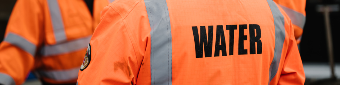 Three Northumbrian Water workers wearing orange jackets
